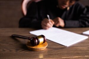 A judge writing with a gavel in the background, representing family law and divorce law proceedings.